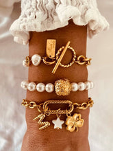 Load image into Gallery viewer, Pearl bracelet with toggle clasp worn on wrist highlighting stylish closure and gold finish
