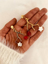 Load image into Gallery viewer, Close-up of NIRA statement earrings highlighting the sculptural gold tree branch with dangling freshwater pearl and red natural stone.
