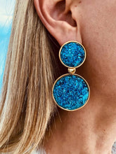 Load image into Gallery viewer, Model wearing NYOKO blue resin statement earrings with gold details, showing their elegant size and lightweight fit.
