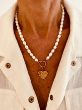 Učitaj sliku u preglednik galerije, Model wearing the Nancy freshwater pearl heart necklace styled with a white shirt, emphasizing its timeless and elegant appearance.

