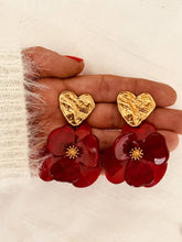 Load image into Gallery viewer, Pair of YNES burgundy flower statement earrings photographed on a white background, highlighting the textured gold heart and handcrafted resin flower
