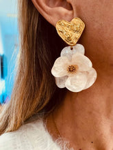 Load image into Gallery viewer, YNES pearl white flower statement earrings worn on the ear, highlighting the glossy resin petals and textured gold heart inspired by timeless femininity.
