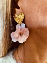 Load image into Gallery viewer, YNES soft pink flower statement earrings styled on the ear, combining a textured gold heart with a feminine resin flower for elegant everyday wear.
