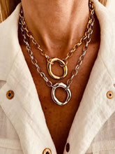 Load image into Gallery viewer, Necklace with gold and silver rings worn by a person against a white shirt background
