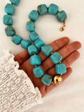 Load image into Gallery viewer, Chunky turquoise bead necklace with gold clasp shown in hand on white background
