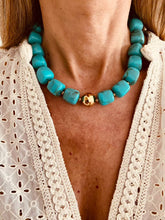 Load image into Gallery viewer, Close-up of chunky turquoise bead necklace with central gold bead on model's neck
