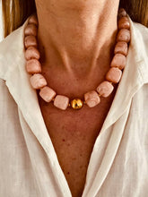 Load image into Gallery viewer, Necklace with pink beads and a gold clasp on a person wearing a white shirt.
