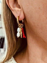 Load image into Gallery viewer, Hoop earrings with coral and pearl charms worn on a model.
