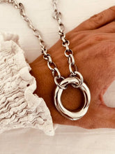 Load image into Gallery viewer, Silver necklace with a large ring pendant on a hand 
