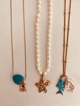 Load image into Gallery viewer, Minimalist coastal necklace with pearl and fish pendants styled on a gold chain
