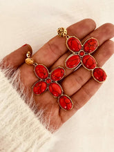 Učitaj sliku u preglednik galerije, Close-up of VLAHA earrings showcasing bold red marbled stones arranged in a striking cross silhouette with textured gold details.
